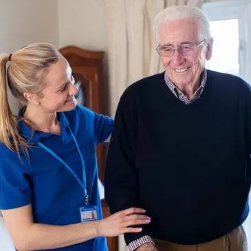 A caregiver offering gentle support to a smiling resident